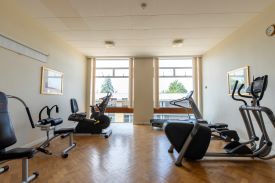 A room with exercise equipment including a treadmill, exercise bike, and weight machines.