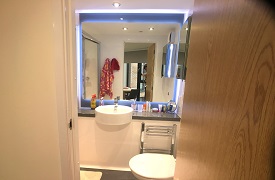 An en suite bathroom with a toilet, sink and mirror.