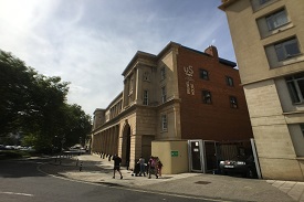 Exterior of a four-storey sandstone building with a sign saying 'Unite Students Brunel House' on one wall.