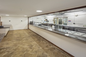 A canteen room with several rows of trays for serving hot food.