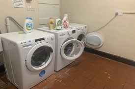 A room with two washing machines side by side.