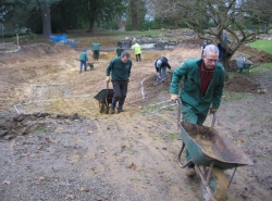 Staff preparing the pond area with a layer of sand