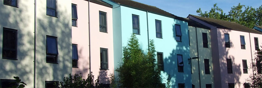 A row of terraced housing buildings in alternating pastel colours.