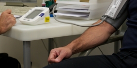 The arm of a man having his blood pressure taken