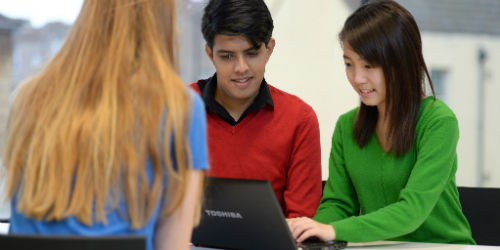 Students studying together on a laptop.