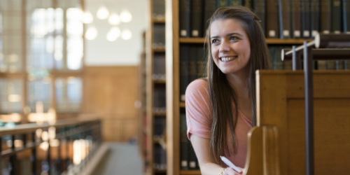 Female student smiling at desk.
