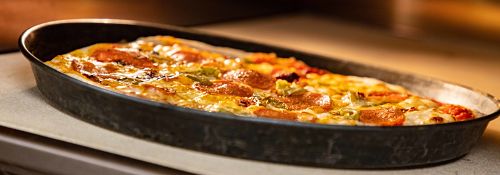 Close up image of pizza being cooked in a pizza oven