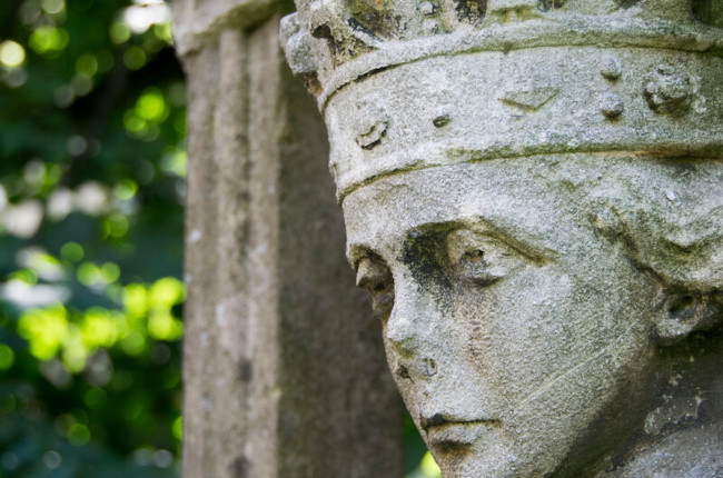 An old stone statue of a woman wearing a crown.