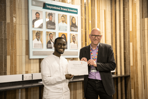 Photo of Abdirahman Sheik Hassan being presented with his certificate by Dean of Science, Jens Marklof.