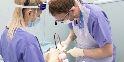 One staff and one student dentist operating on a member of the public.