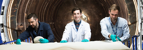 Three men in lab coats with composites materials