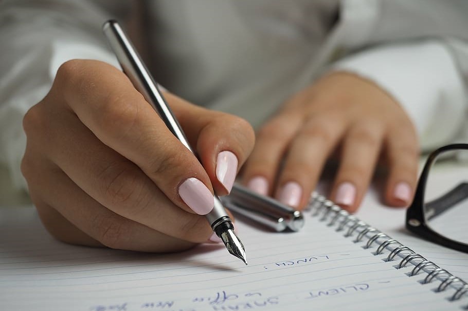 A person working on a paper checklist with a pen.