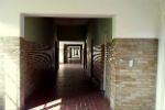 Atmospheric photo of a long corridor, with patches of light and shade.