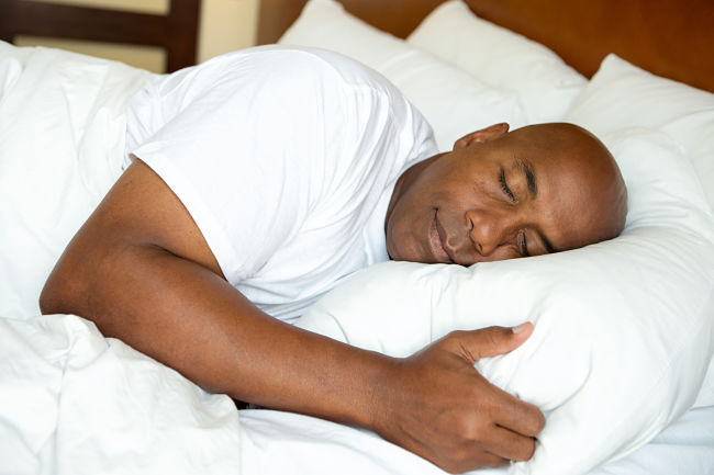 An image of a man asleep in bed