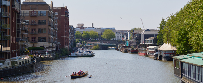Shot of the canal taken from Bristol bridge with a rowing boat in the water.
