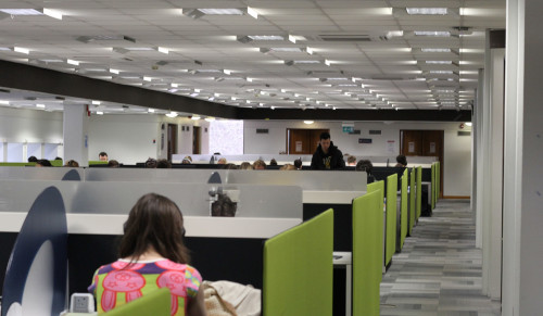 Rows of desks with students working at them.
