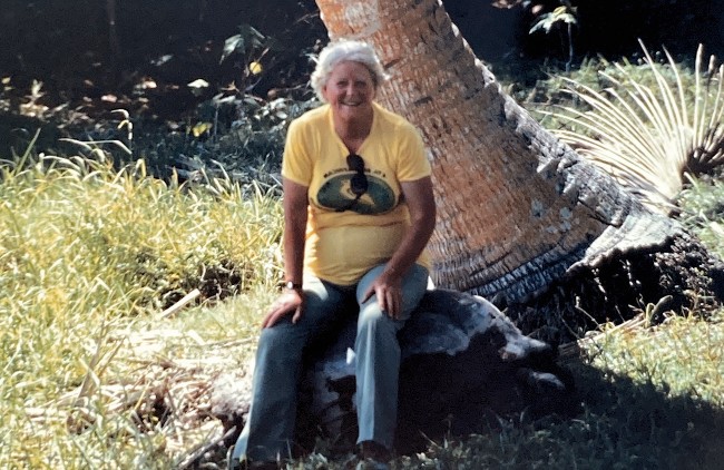 Angela Hughes sitting on a giant tortoise