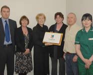 Lynne Hill, Chief Executive (3rd left), presenting an 'LVS' cake to members of staff on the first day of business