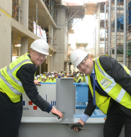 Professor Eric Thomas, Vice-Chancellor of the University of Bristol, with Paul Tuplin, Commercial Director for VINCI Construction UK, tighten a bolt to mark the topping-out of the new Life Sciences building