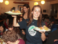 Volunteer serves food at previous FoodCycle event