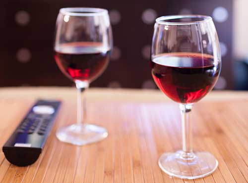 Image of two wine glasses and a remote control