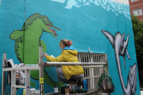 Image of Alex Lucas creating the Uncertain World mural