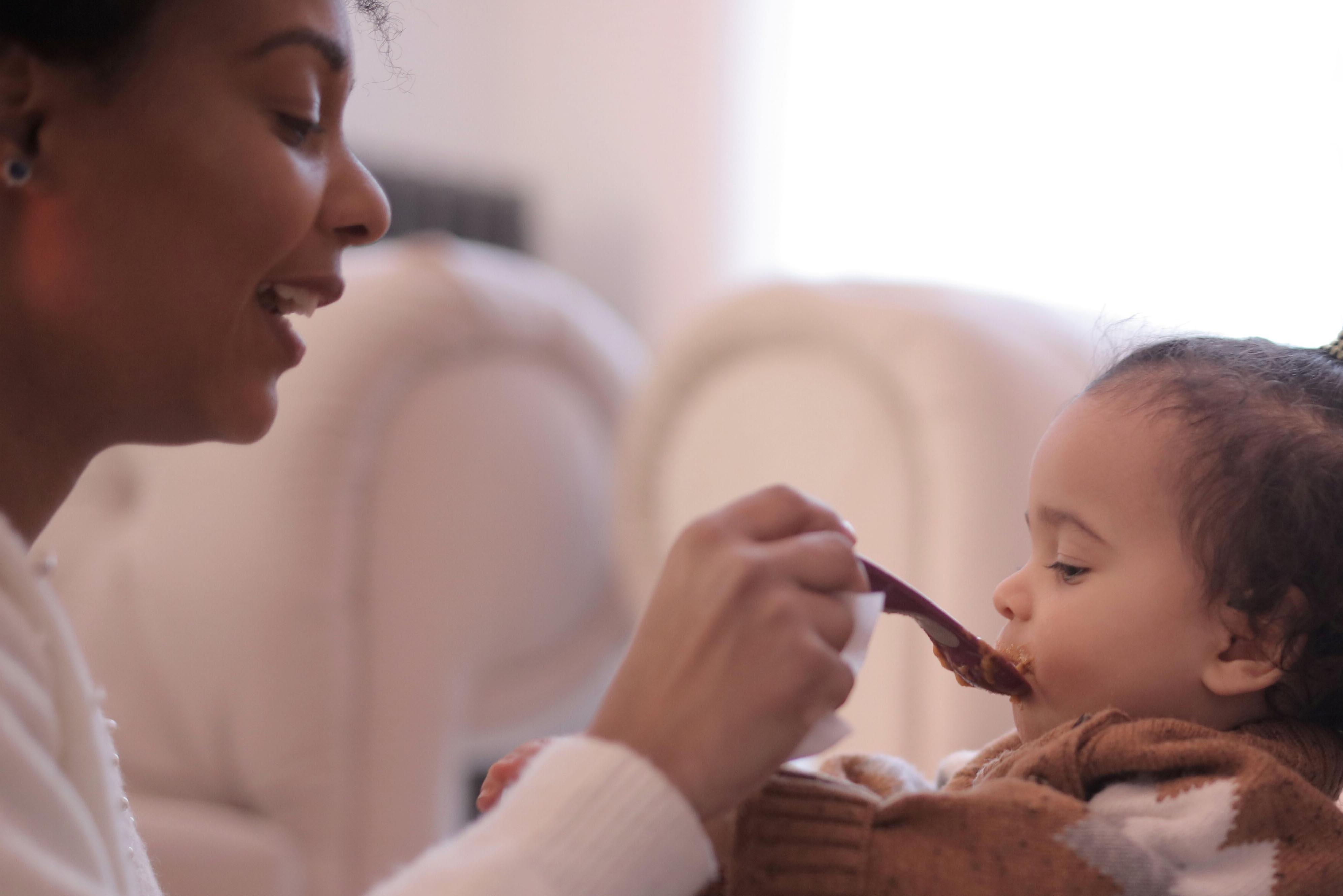 A women feeding a toddler