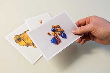 Image of a hand holding a photograph of some beads