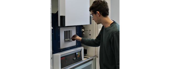 Research student operating a muffle furnace