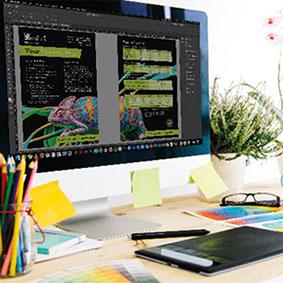 Image of Print Services Design work displayed on a screen on a work desk