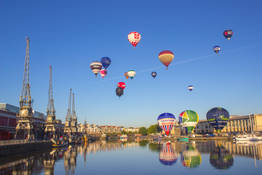 Hot air balloons taking off from and flying over Bristol Harbourside.