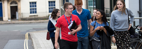 A group of people walking behind a Bristol student ambassador in a red t-shirt. 