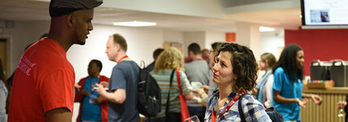 Visitors interestedly talking to student ambassadors in one of the refectories on campus at a postgraduate open day.
