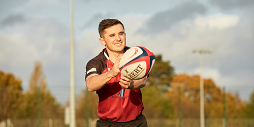 A student playing rugby.
