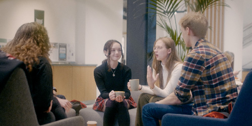 A group of students chatting over a coffee in senate house