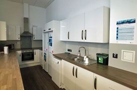 A kitchen pspace with a sink, an oven and hob, two fridge freezers and a dishwasher.