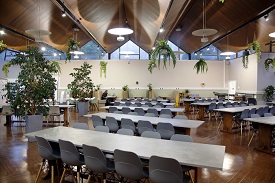 A large dining hall with many tables and chairs around each of them.