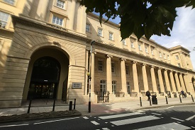 Exterior of a four-storey sandstone building with a sign at the entrance saying 'Brunel House'. There is a zebra crossing at the road outside the entrance.