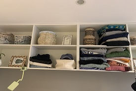 Bedroom shelves with clothes and belongings in them.