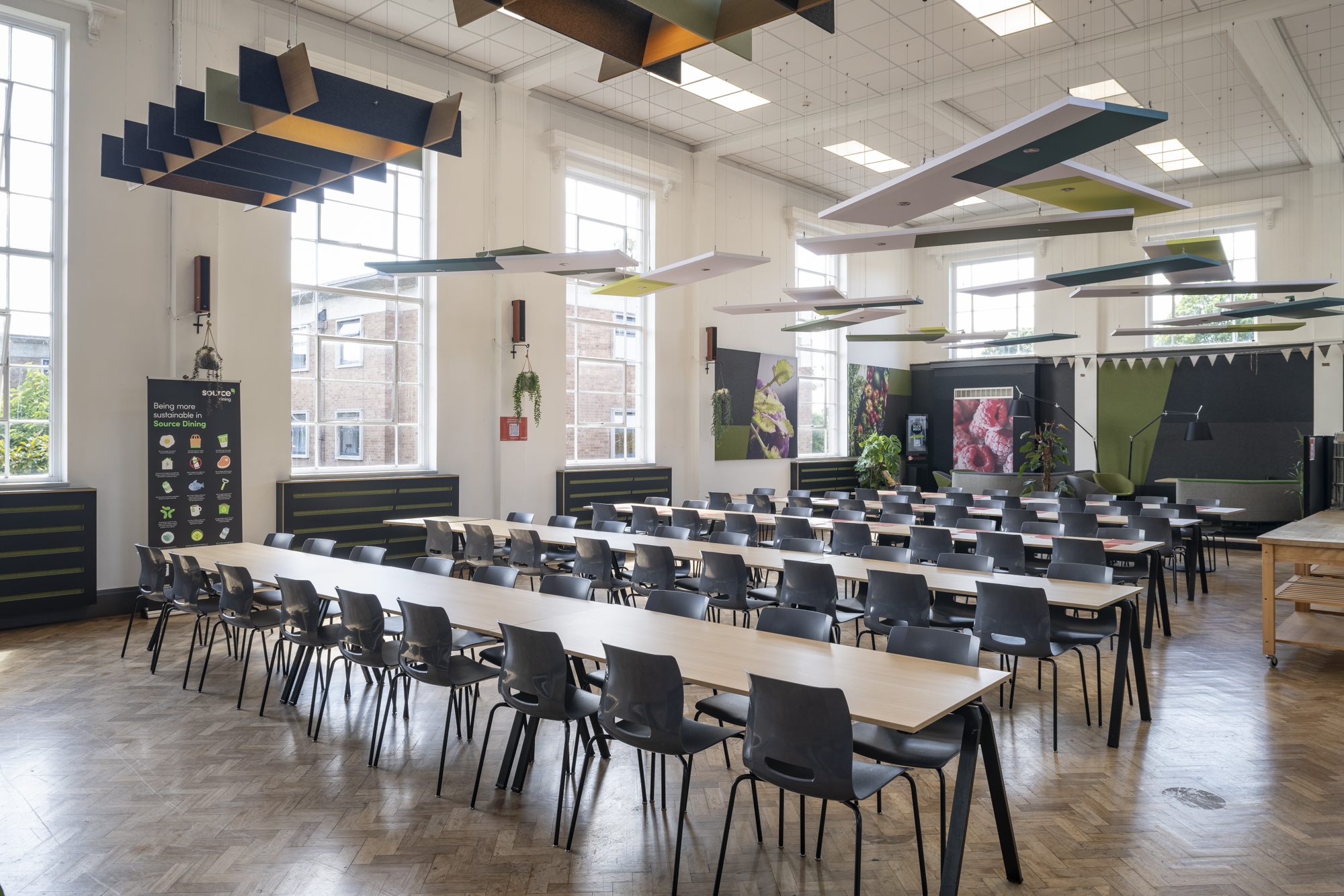 A large room with five long tables and chair surrounded each of them.