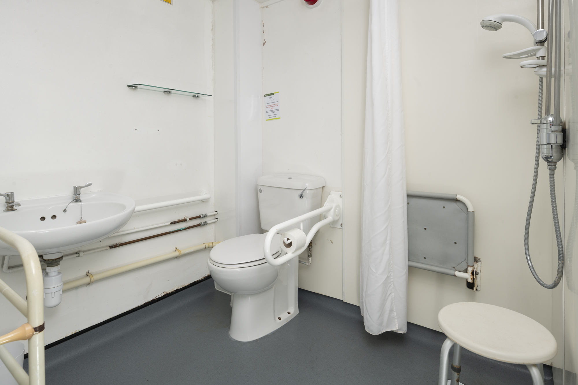 A bathroom with a toilet, sink and mirror.