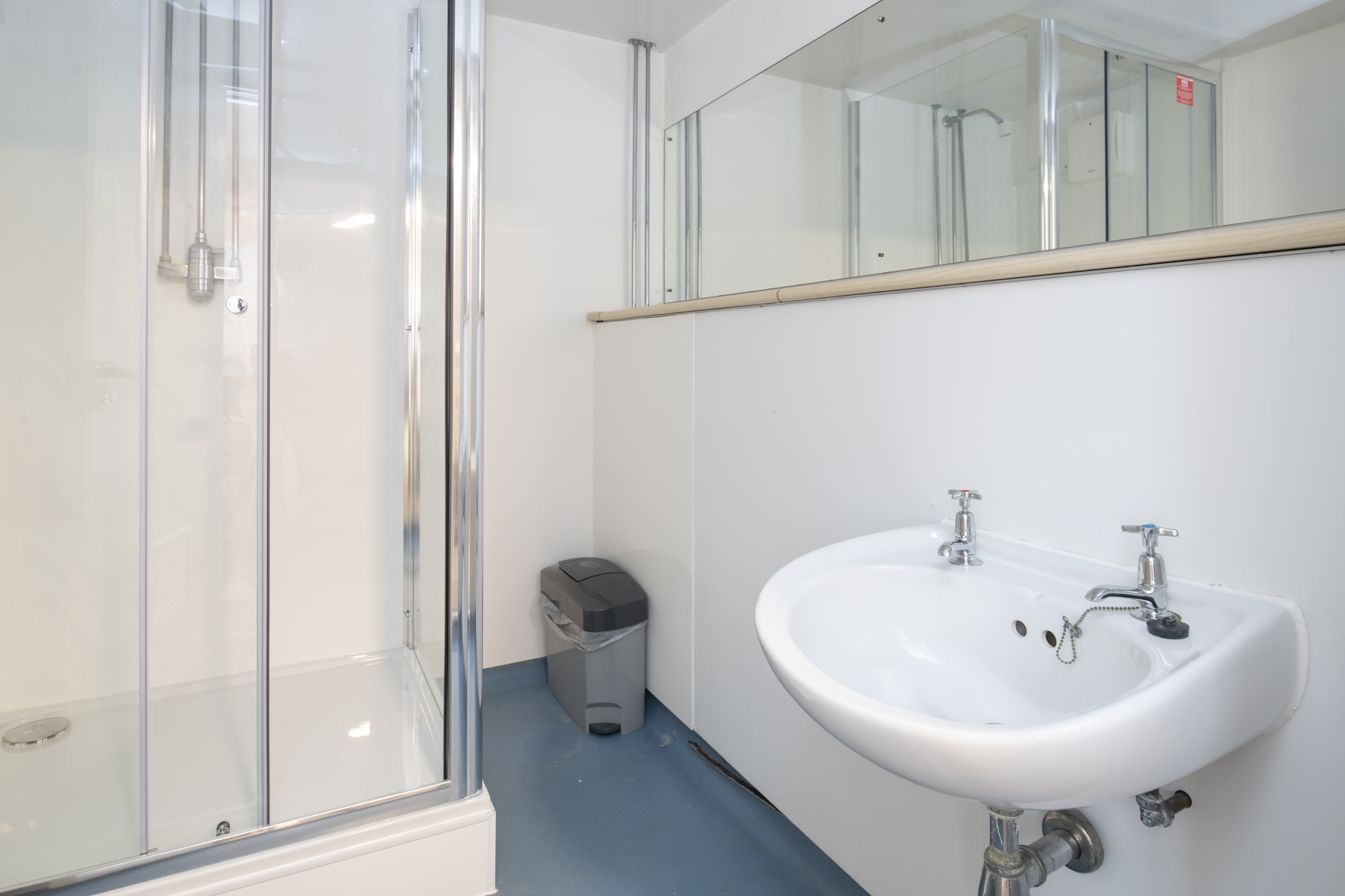 A bathroom with a shower and sink.