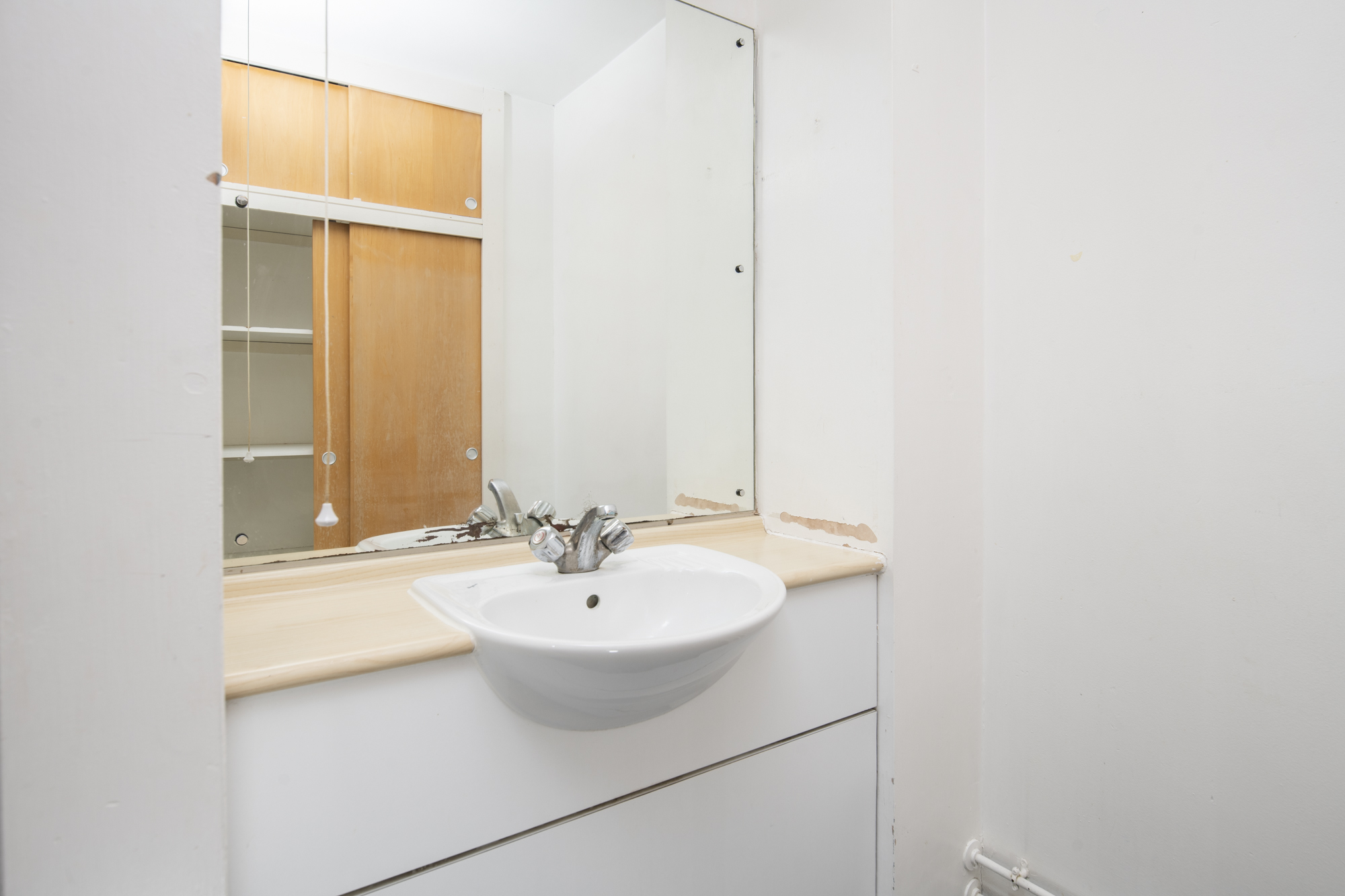 A sink built into a shelf with a large mirror behind.