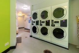 A laundry room with six washer dryers.