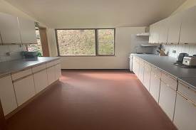 A large kitchen with an oven and hob, and lots of cupboards and drawers.