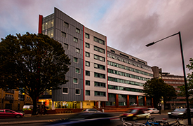 Exterior of a modern eight-storey building next to a dual carriageway.