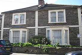 Exterior of two grey brick terraced two-storey houses.
