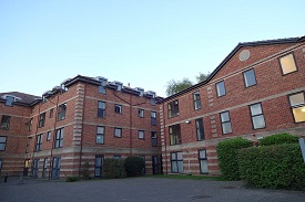 The exterior of a large four-storey red brick building.