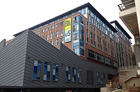 The exterior of a modern multi-storey building. There is a sign on one wall 'University of Bristol, Unite Students'.