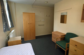 View of bedroom showing single bed, chair, storage units, wardrobe and radiator